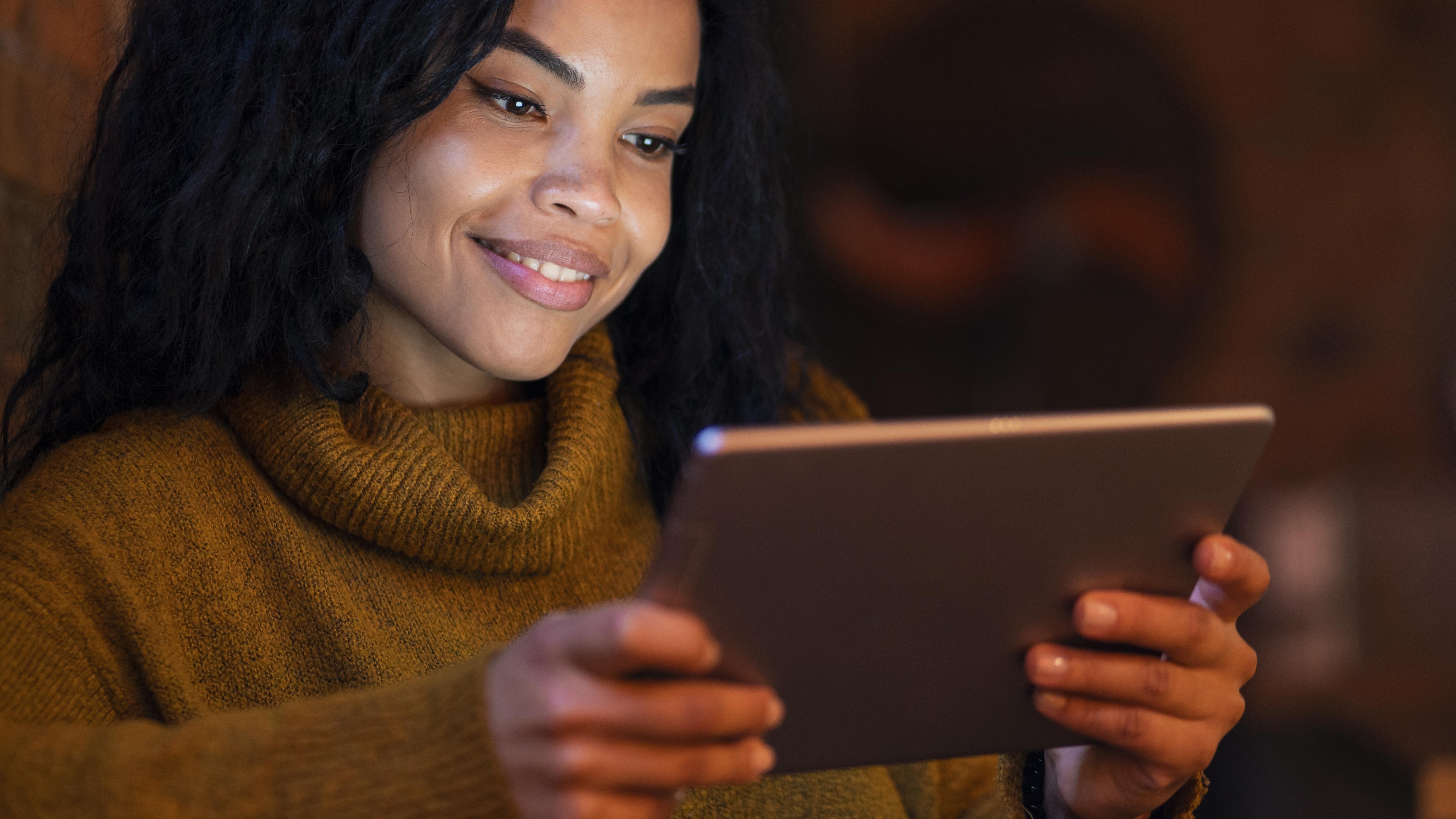 Mujer leyendo en tablet dentro de una cafetería
